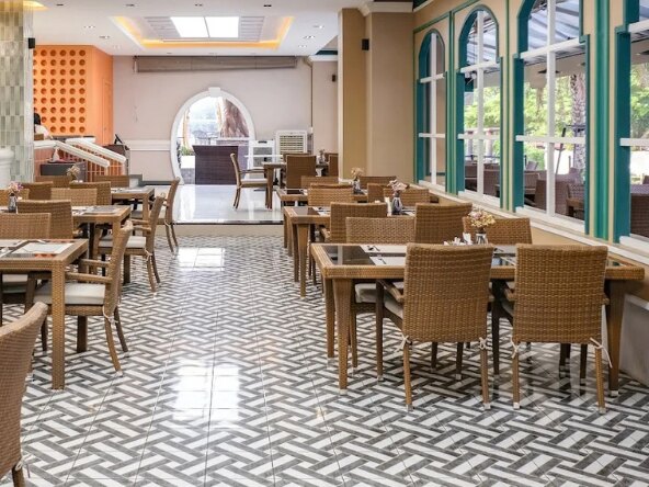 The residence dining room, set tables beside arched windows