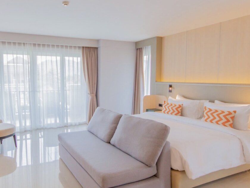 A residence suite with a king bed, sitting area and balcony doors